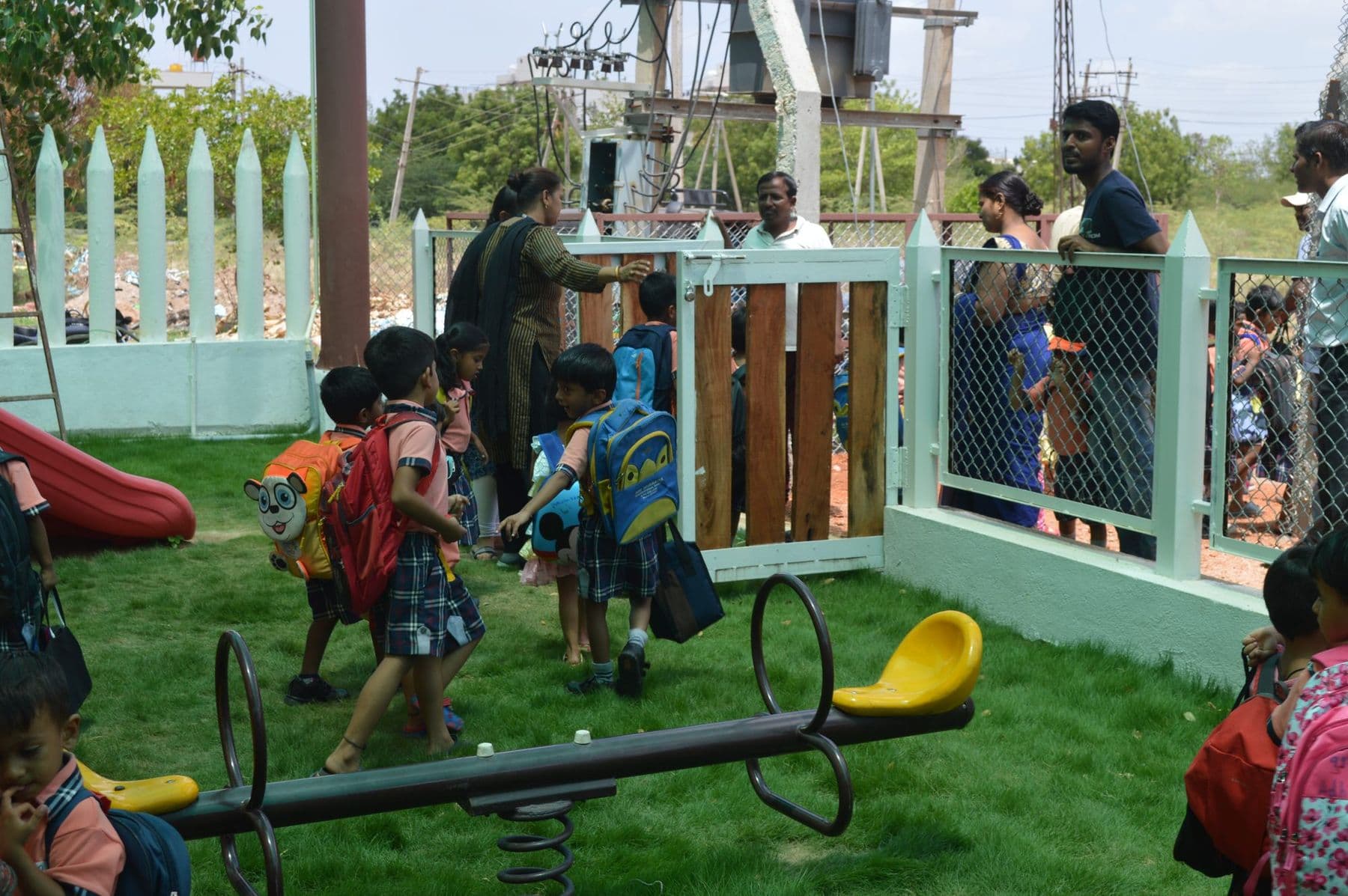Children with backpacks arriving at the play garden with their parents