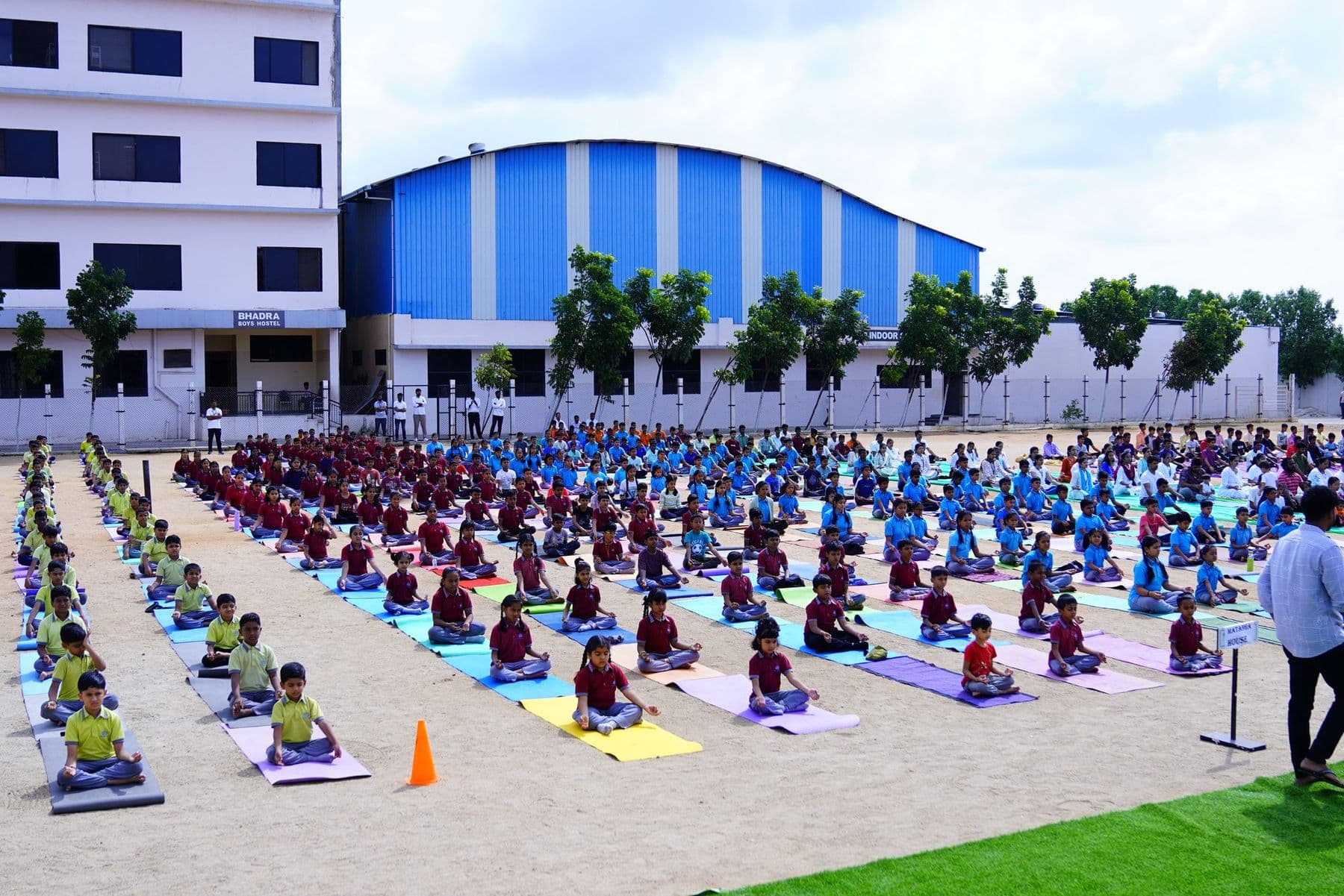 The whole school doing yoga on colourful mats on the sports ground