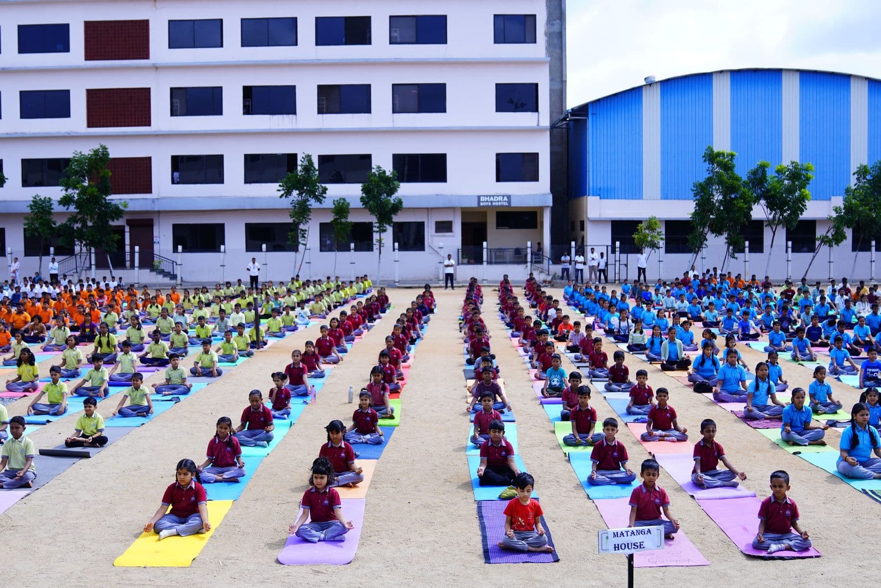 Rows of children doing yoga on the school ground