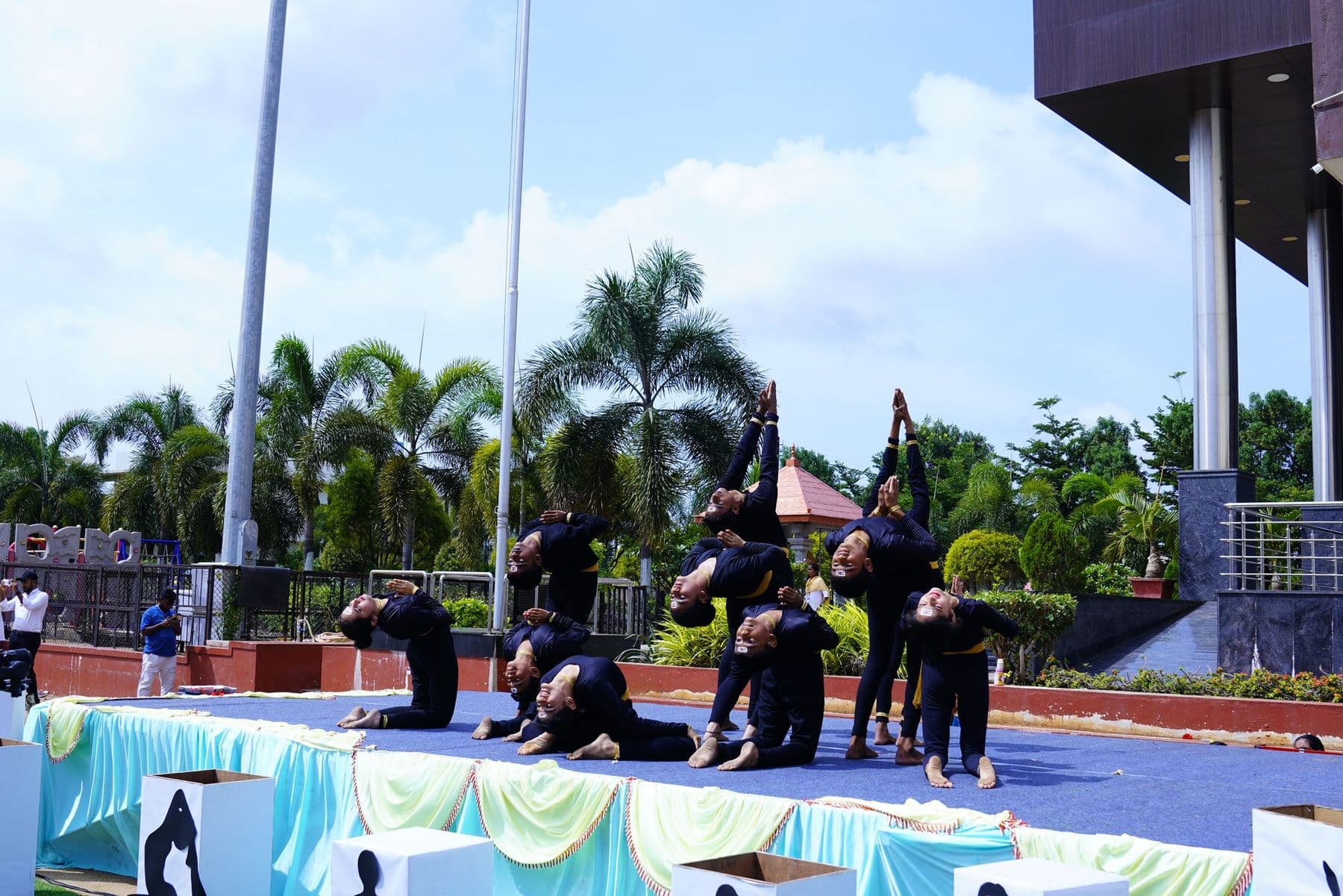 Yoga performers in black and yellow on the stage