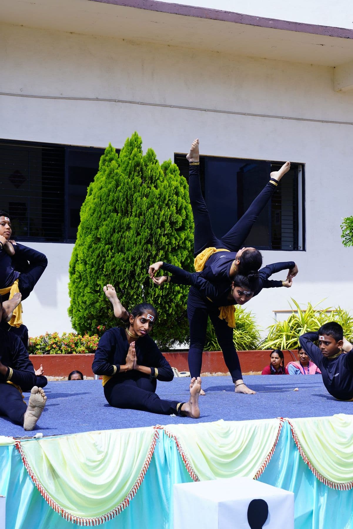 A performer holding a balancing yoga pose on stage