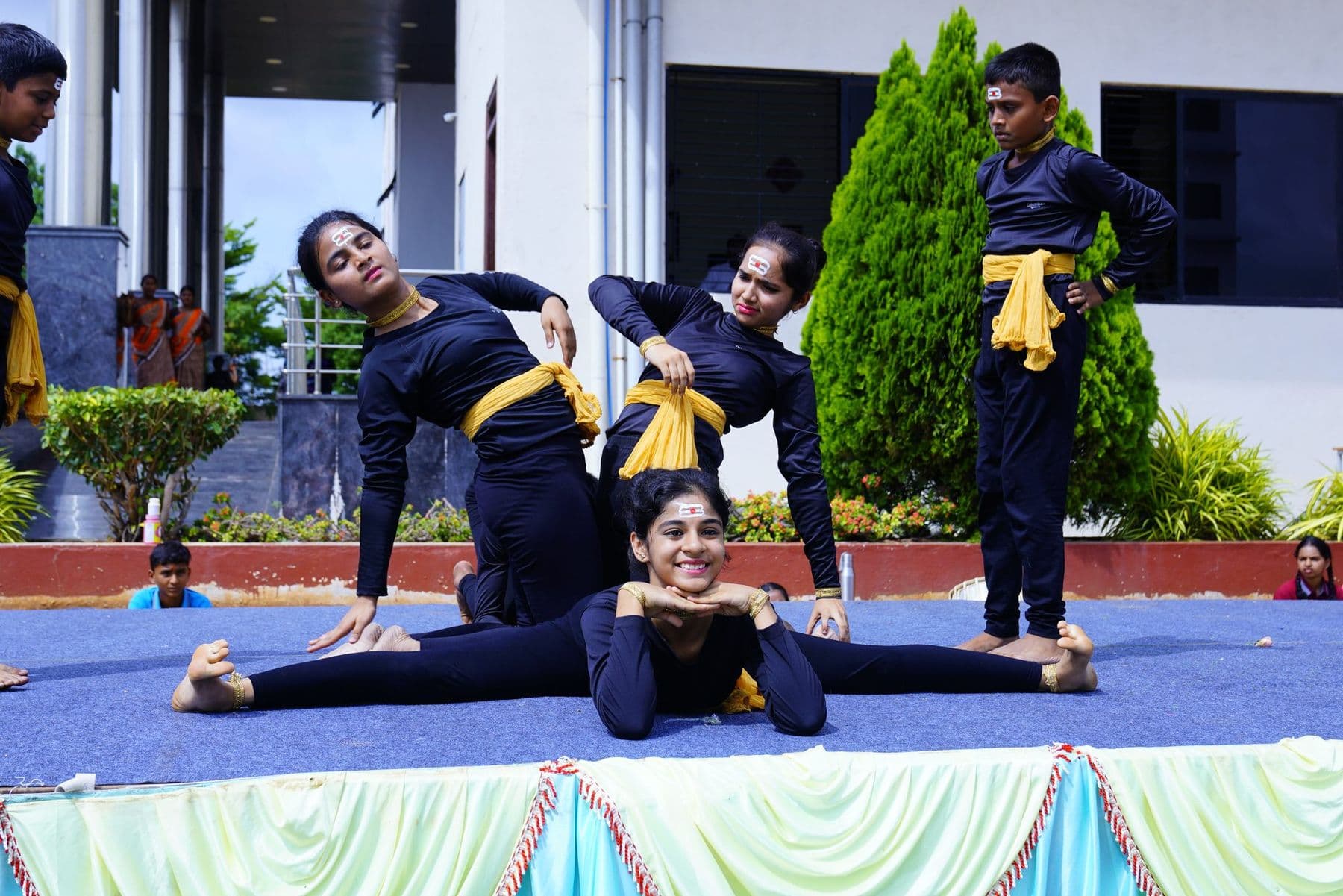 Yoga performers showing a split and a back-bend on stage