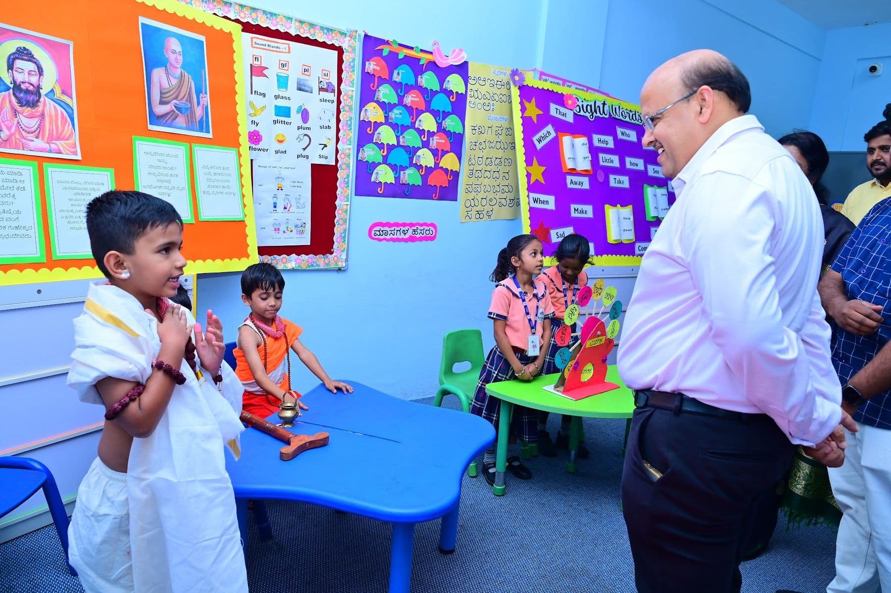 A boy in a white dhoti presenting to a guest