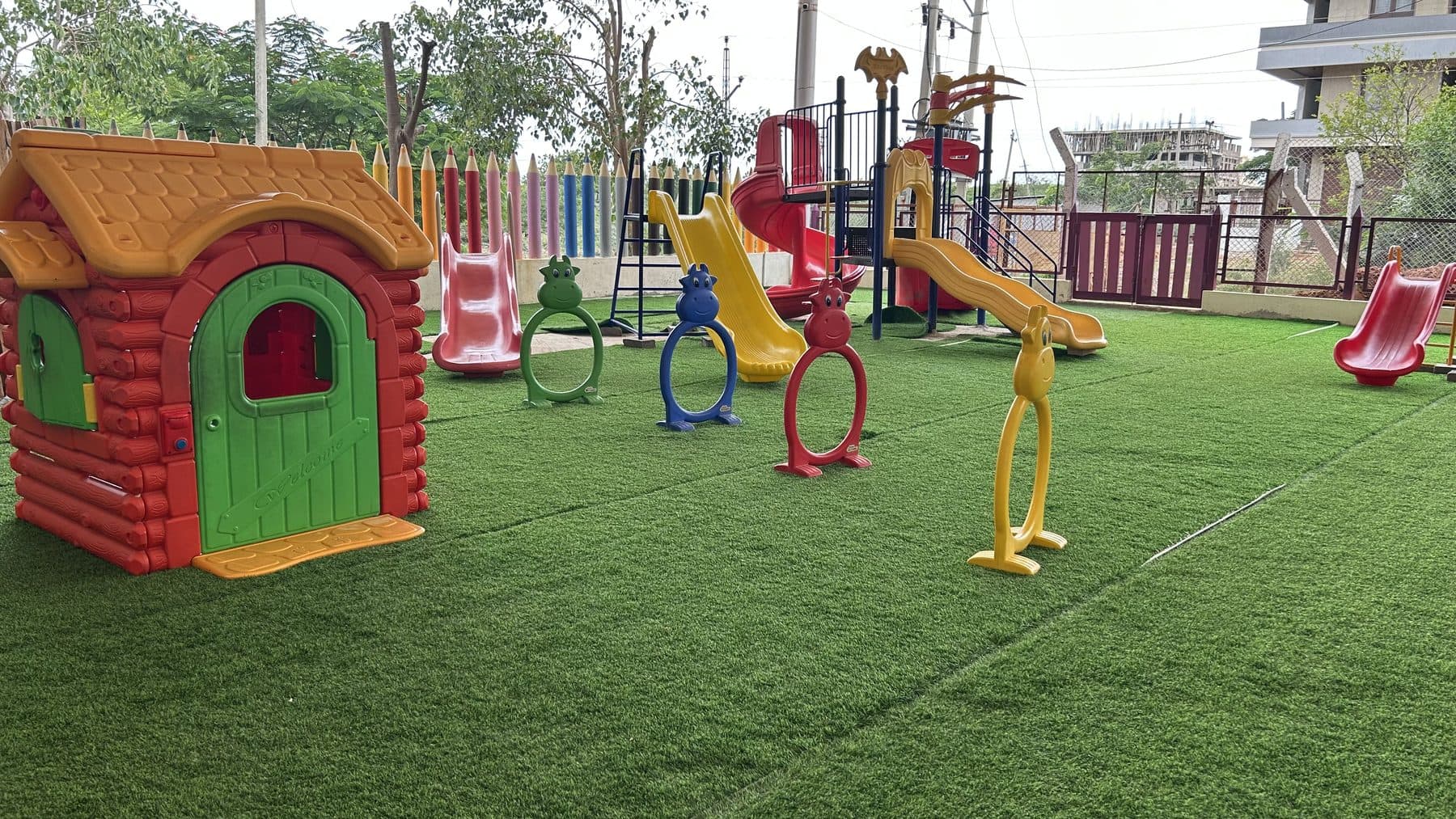 Play house, hoops and slides across the play garden