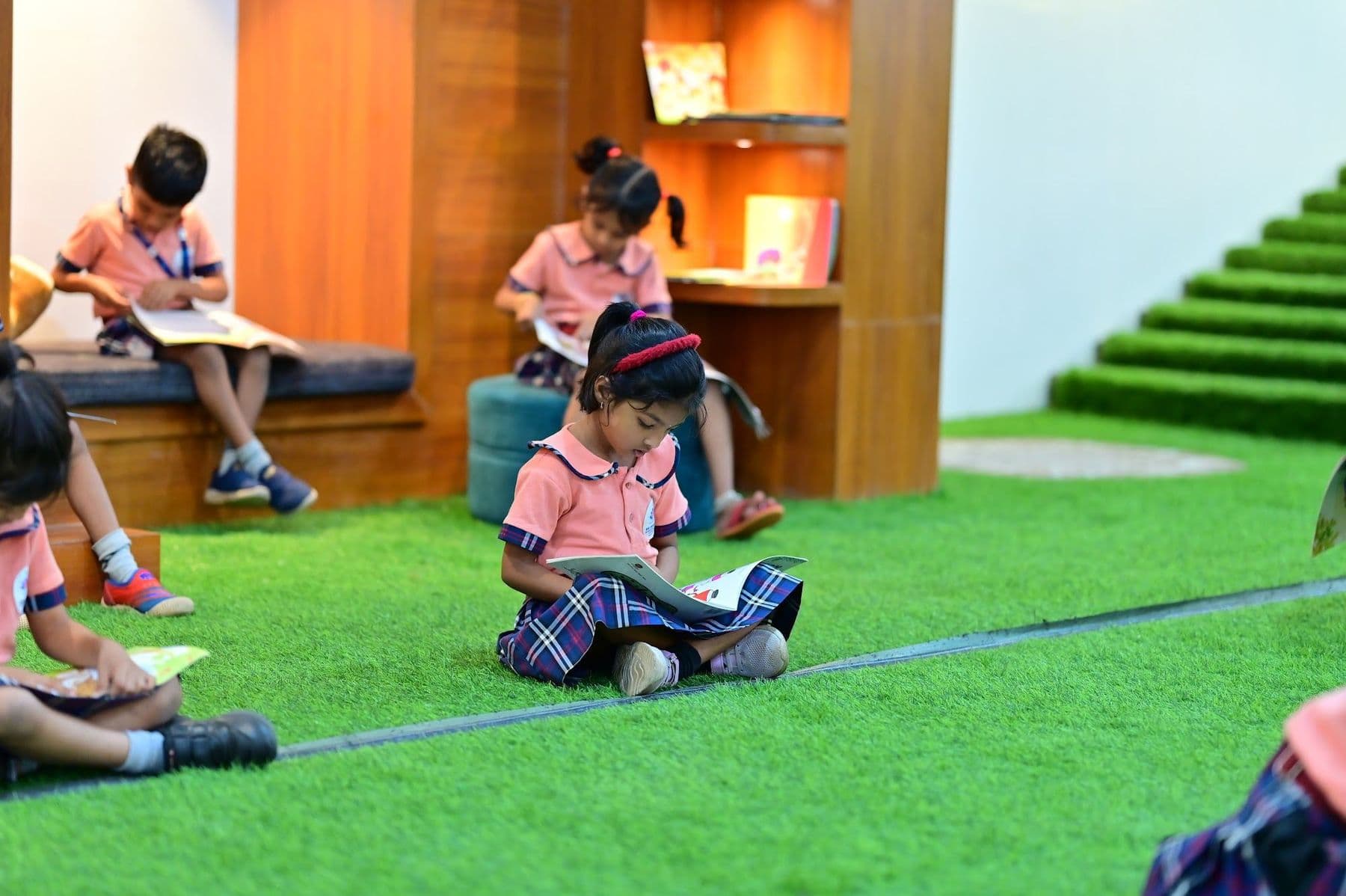 Children curled up with picture books in a cosy reading nook