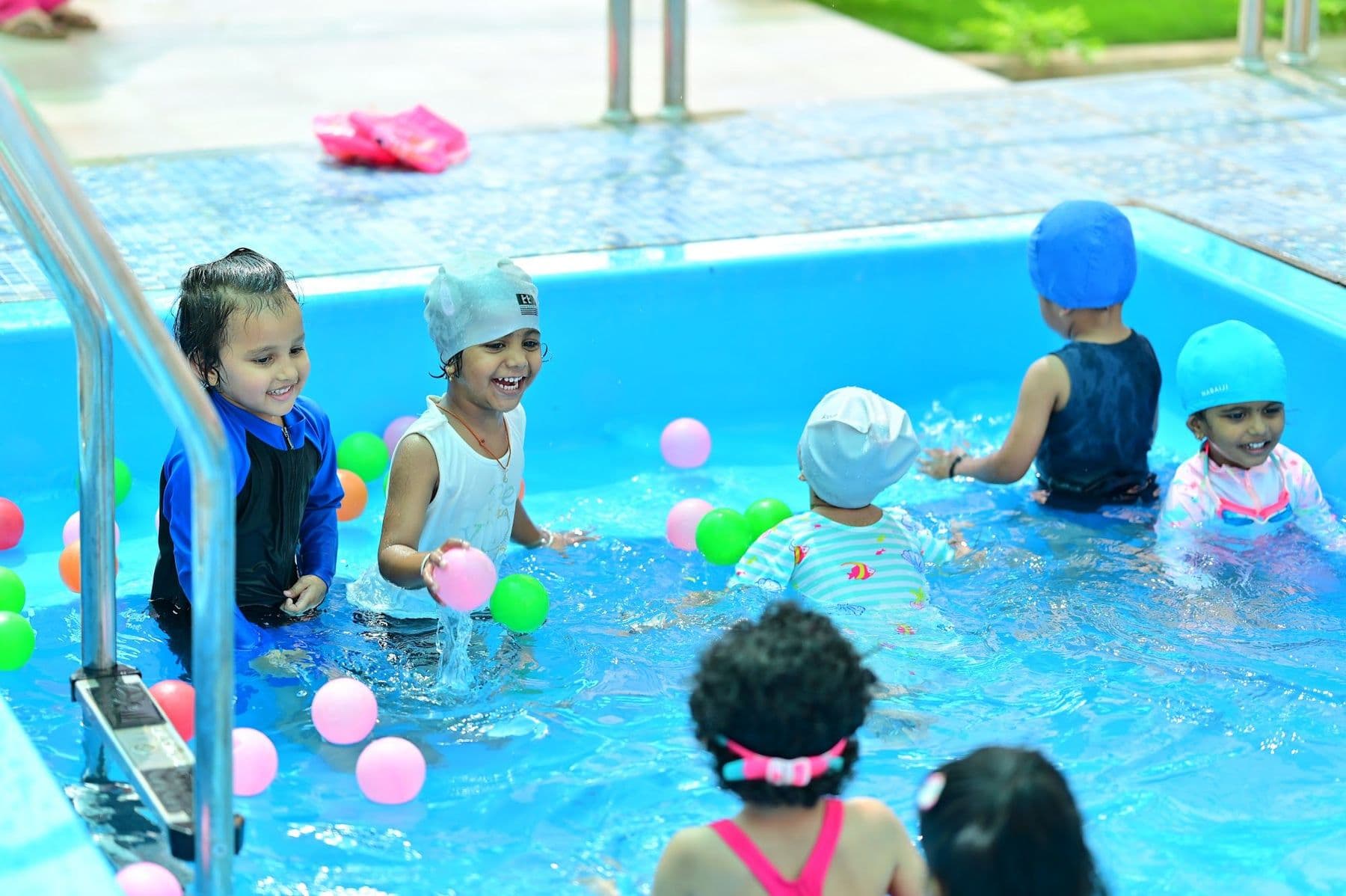 Children splashing in the pool with coloured balls