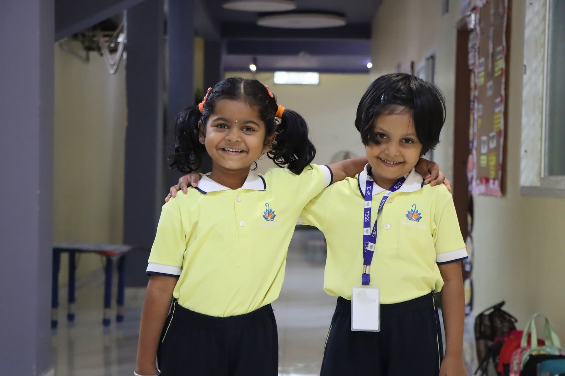 Two friends with their arms around each other in the corridor