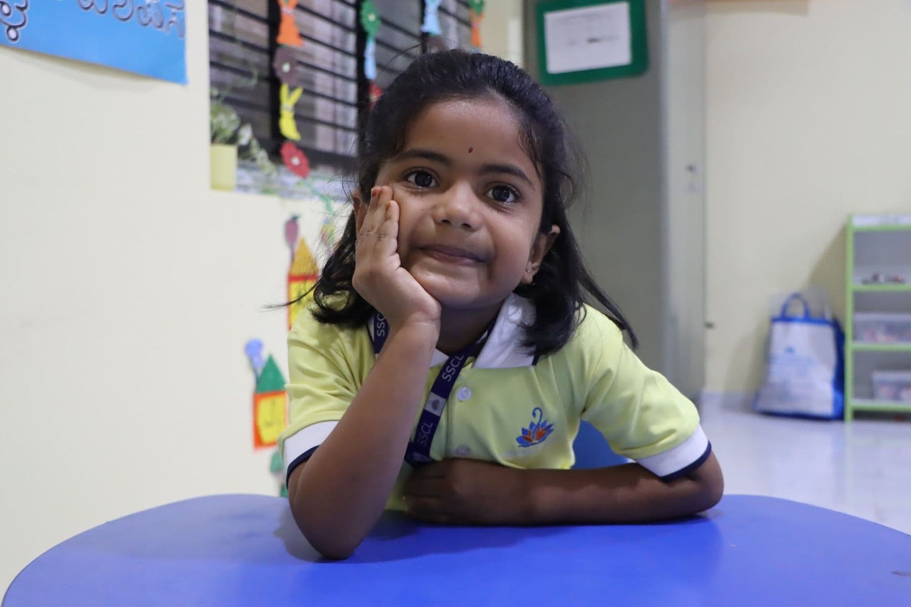 A girl smiling with her chin in her hand