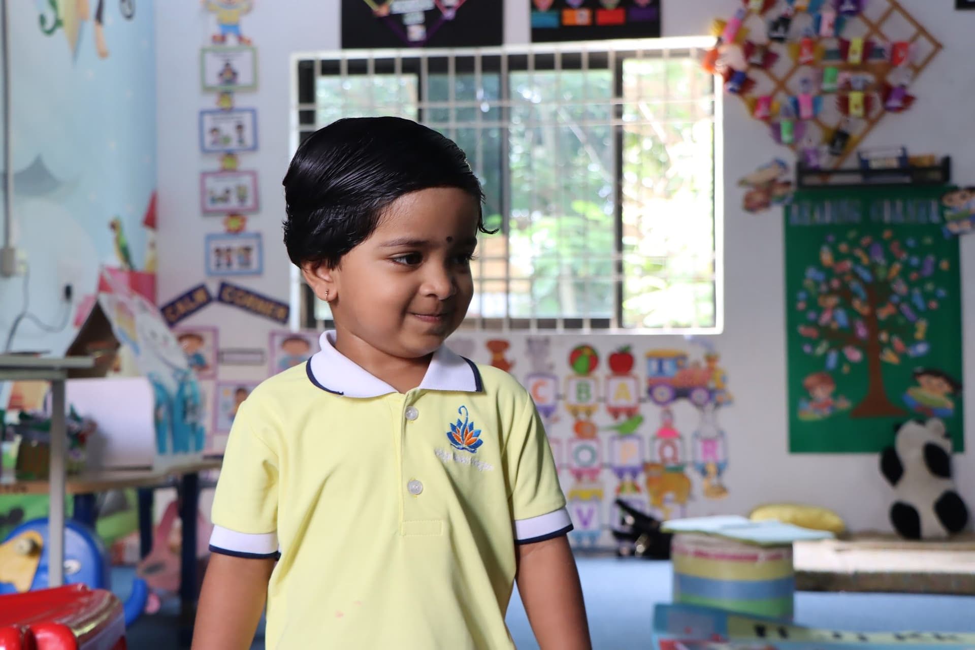 A toddler smiling in the classroom