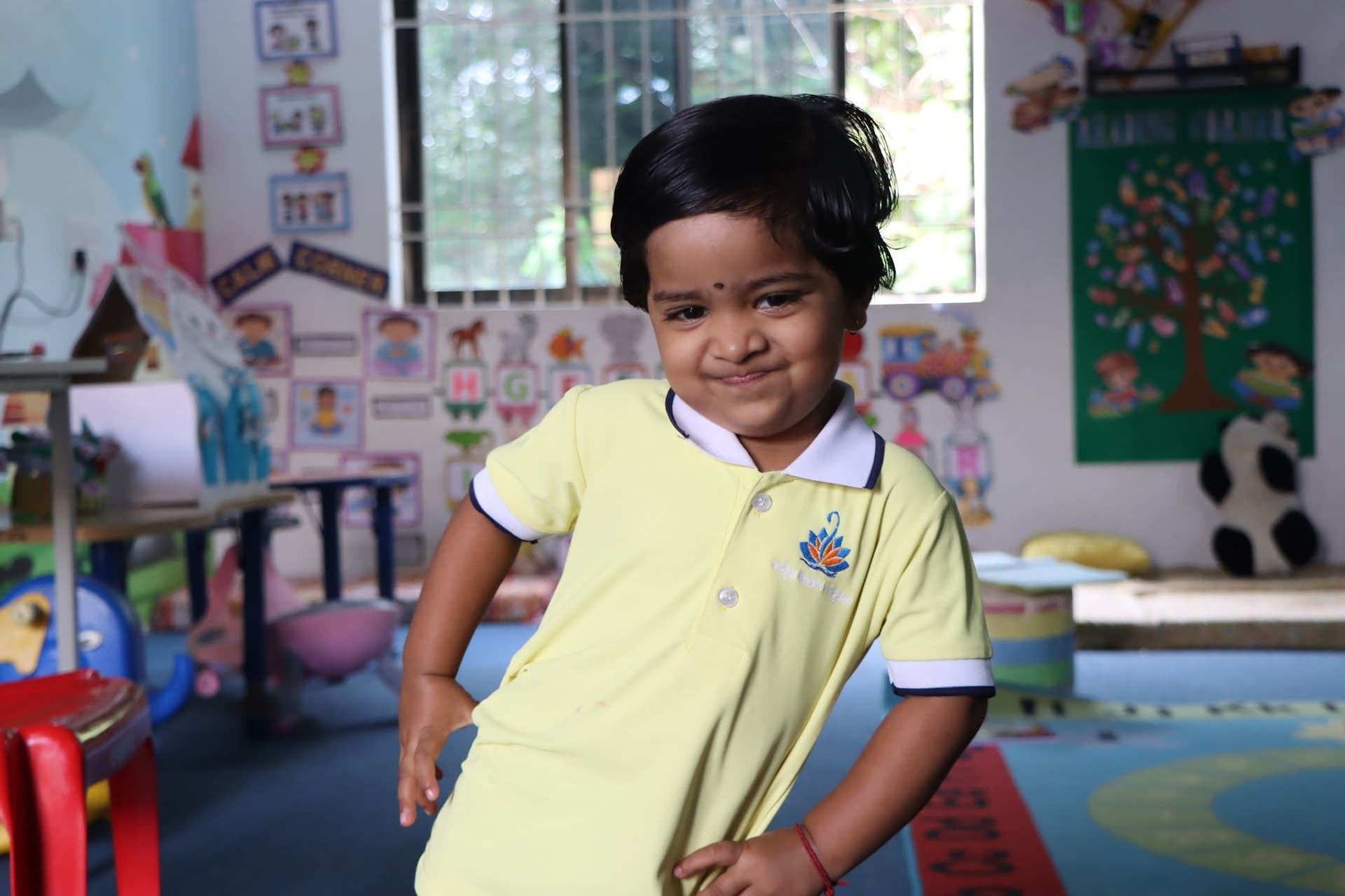 A smiling toddler in the classroom