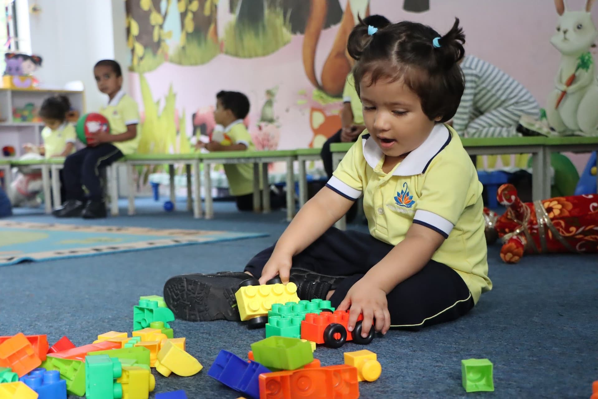 A toddler pushing a toy car among the blocks