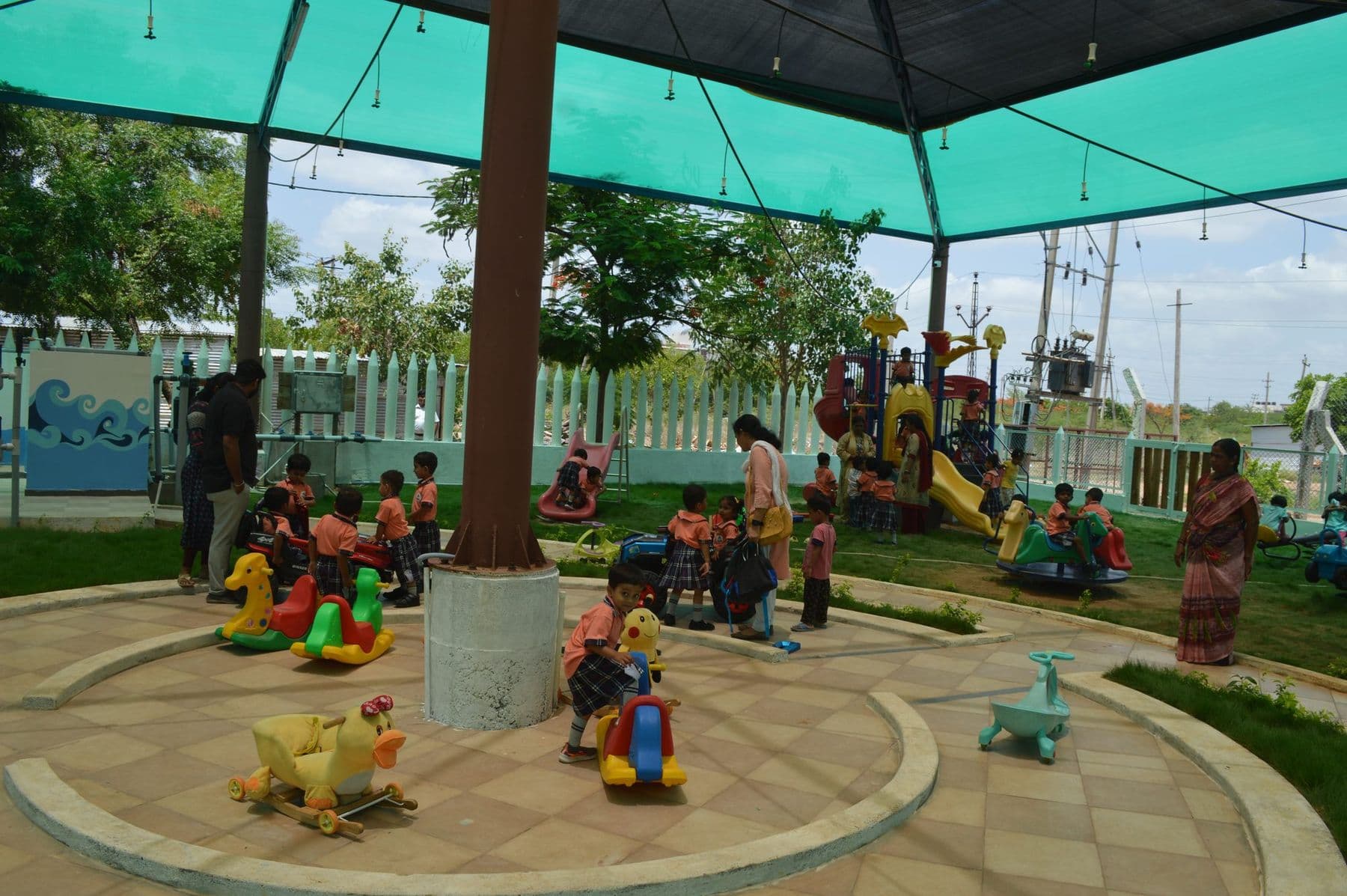 Children on rocking animal rides under the shade canopy