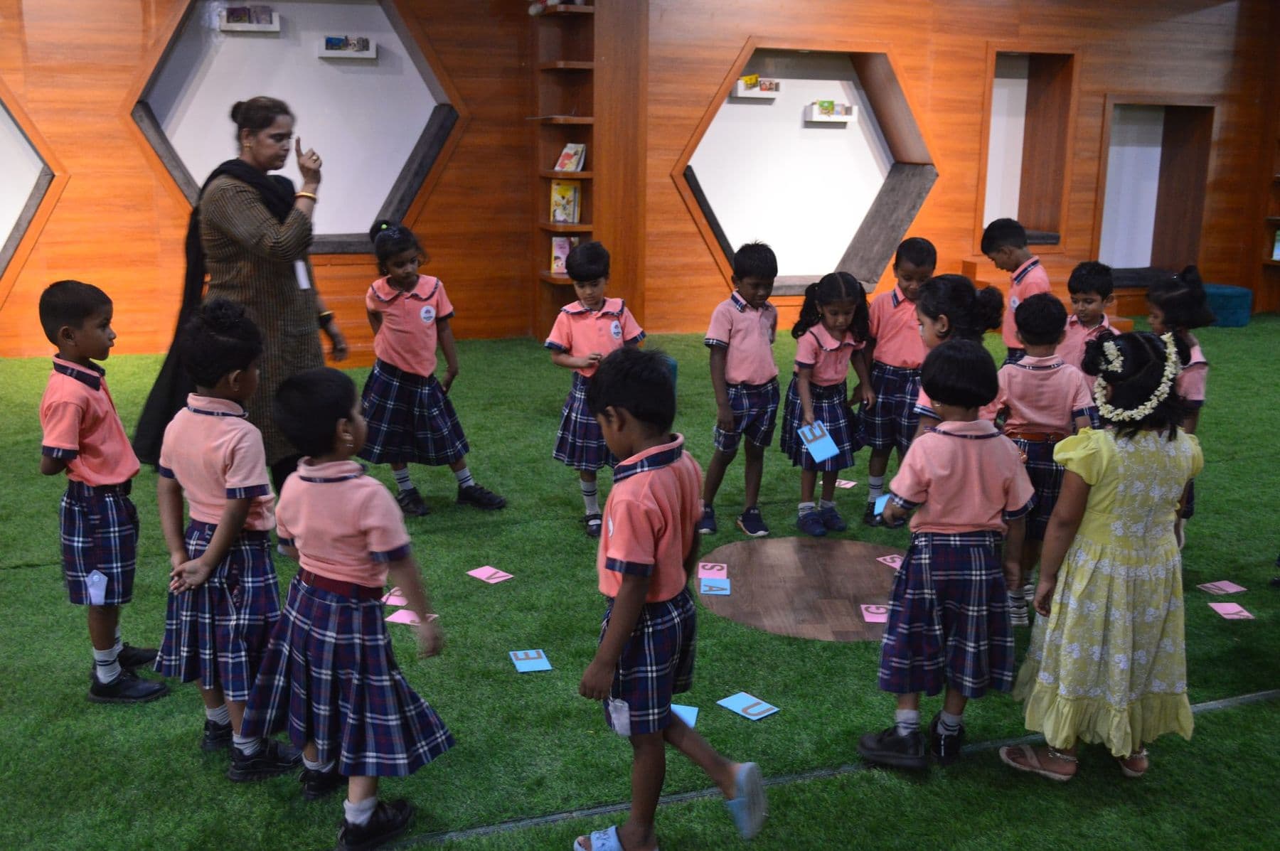 Children picking up picture cards from the grass carpet
