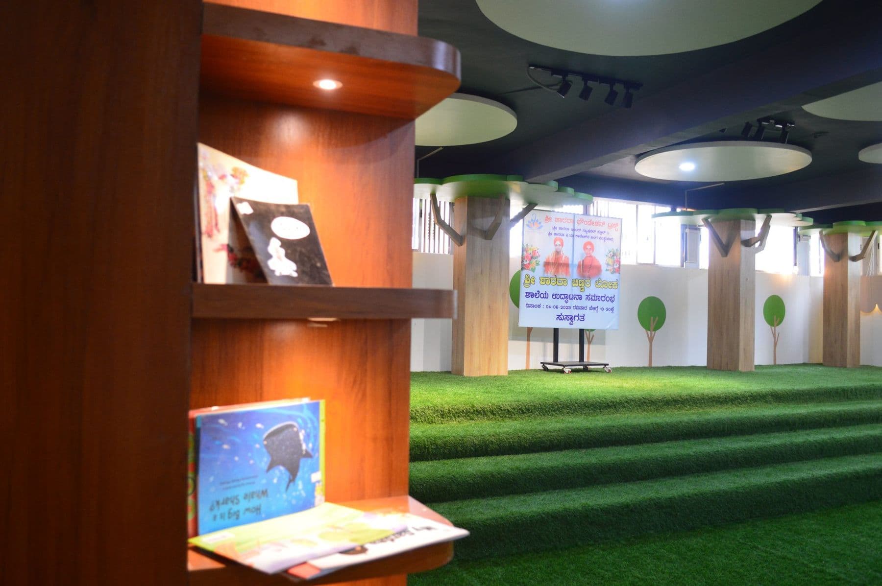 Picture books displayed on wooden shelves in the library hall