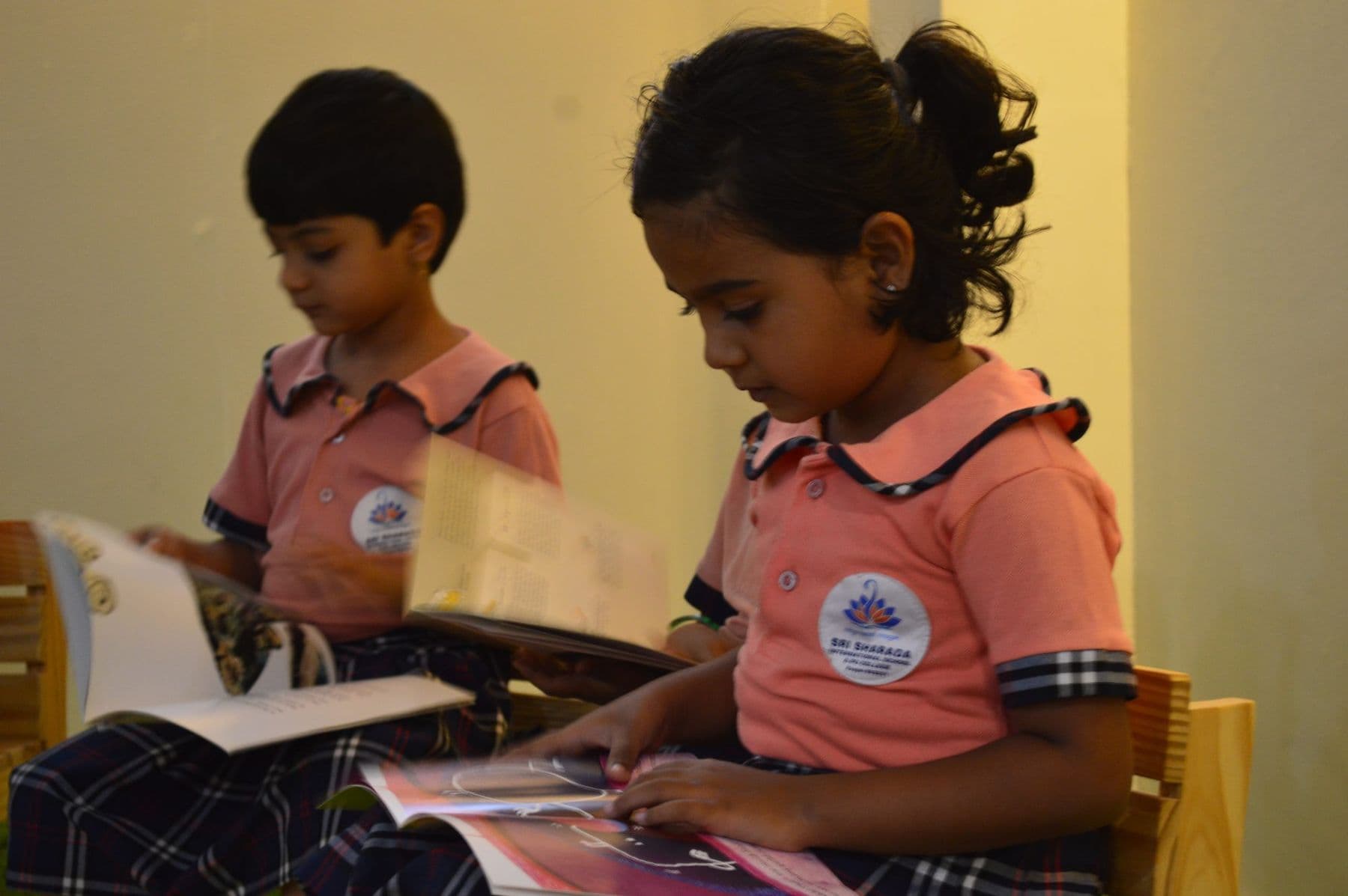 A girl and a boy reading picture books side by side