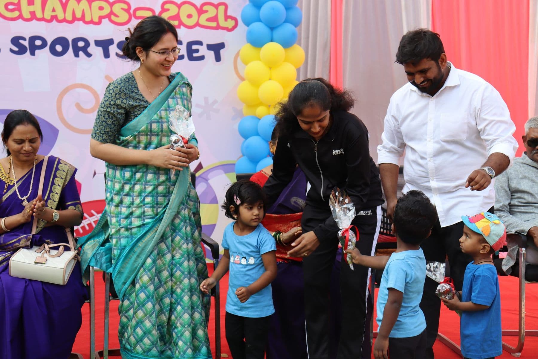 A guest giving medals to children at the Little Champs sports meet