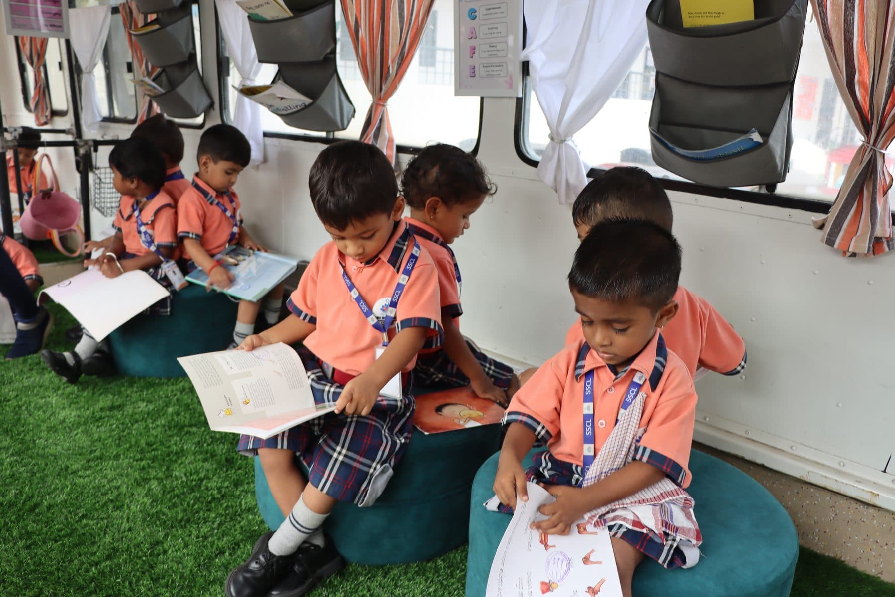 Children reading picture books inside the library bus