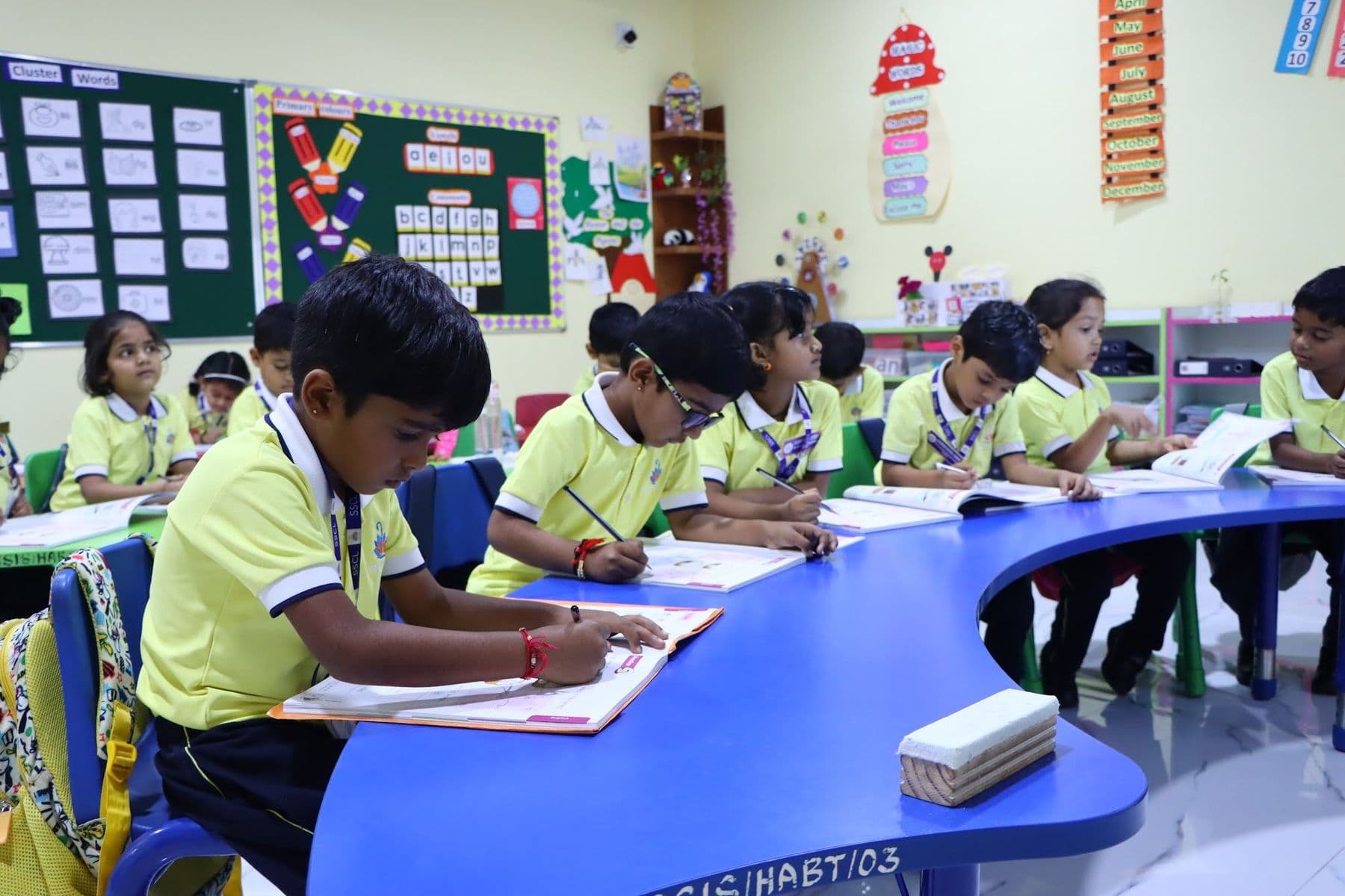 A boy writing at a blue curved table